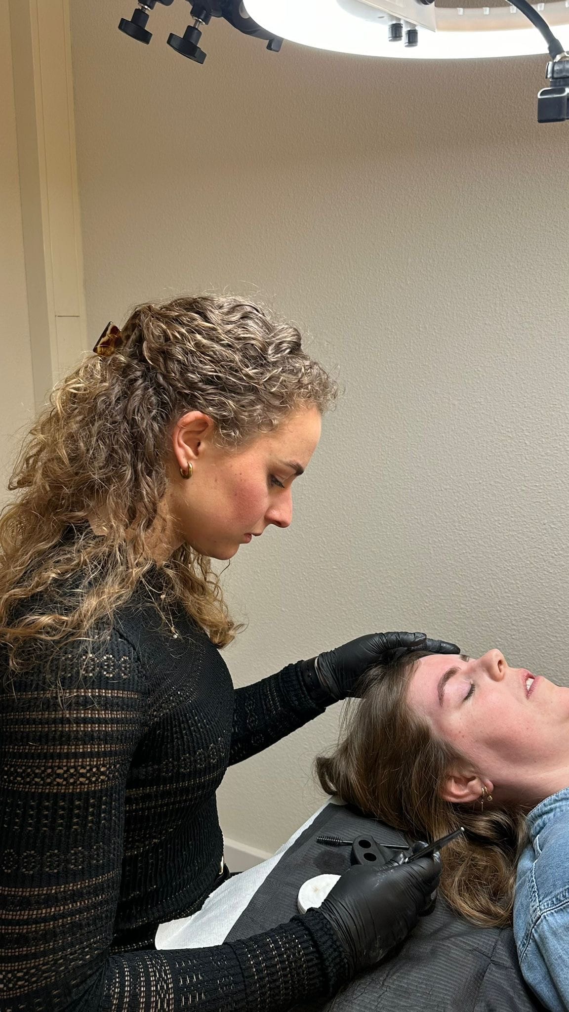 Permanente make-up wordt gezet bij een klant die met gesloten ogen op de behandelstoel ligt