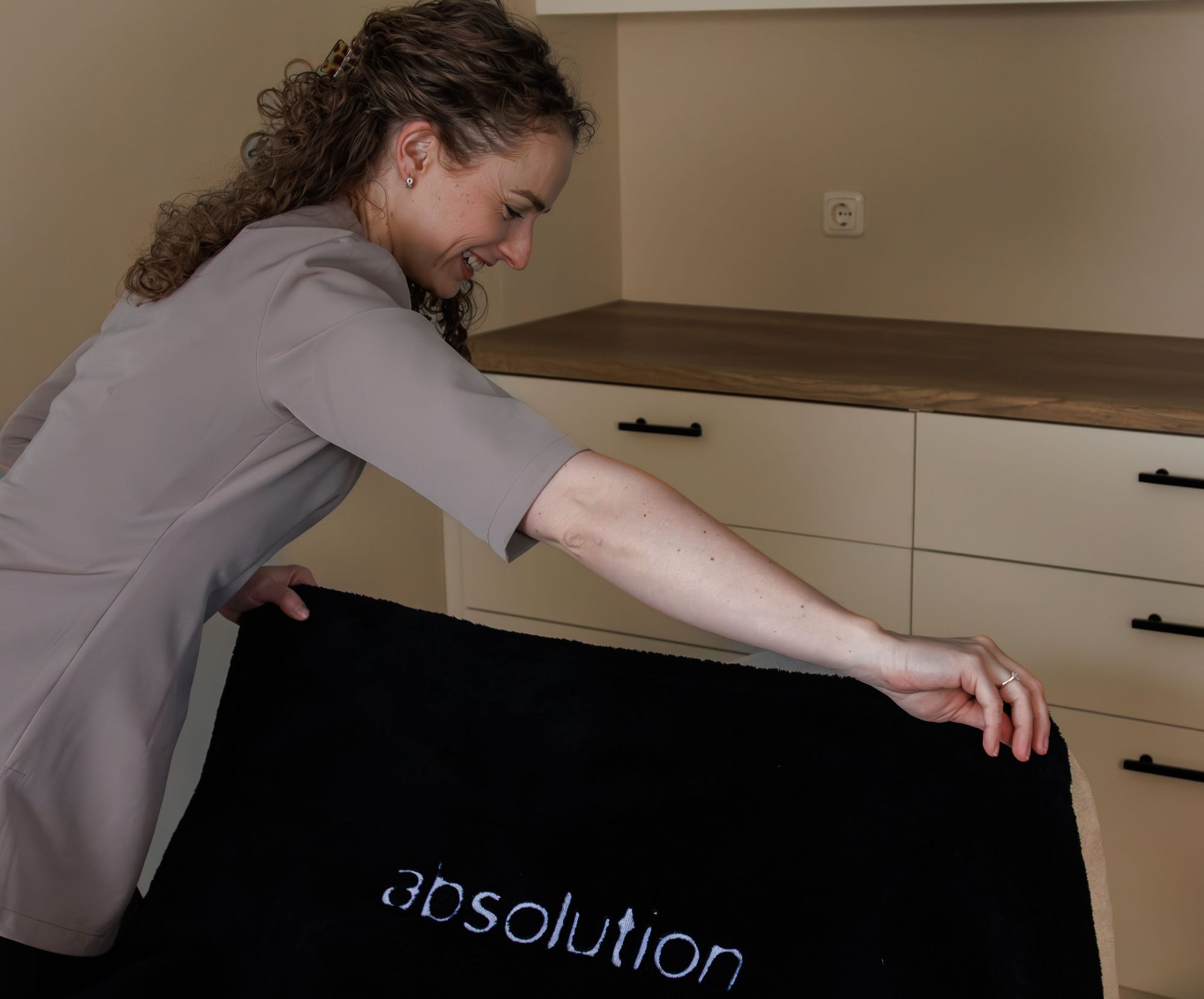 Linda legt een Absolution-handdoek klaar op de behandelstoel