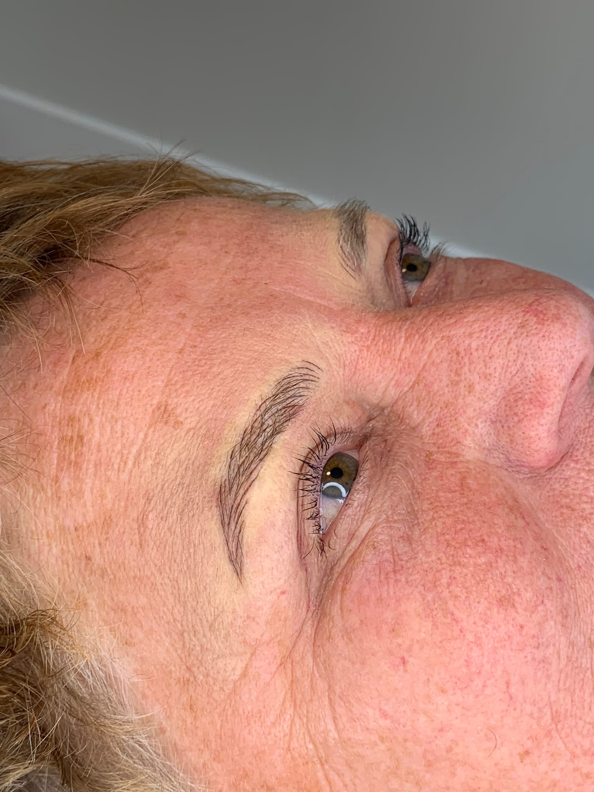 Close-up van een wenkbrauw met permanente make-up, van opzij gezien