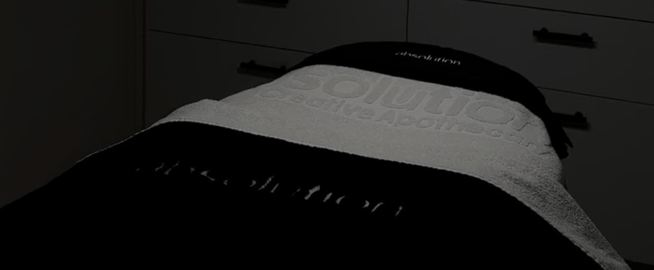 Behandelstoel met Absolution-handdoek in gedempt licht